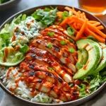 Buffalo chicken rice bowl with avocado, blue cheese, carrots, and lime over white rice.
