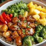 Pineapple chicken and rice bowl with teriyaki chicken, broccoli, red bell pepper, and fresh pineapple chunks.