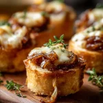 French onion soup bites with caramelized onions, melted cheese, and fresh thyme on toasted baguette rounds
