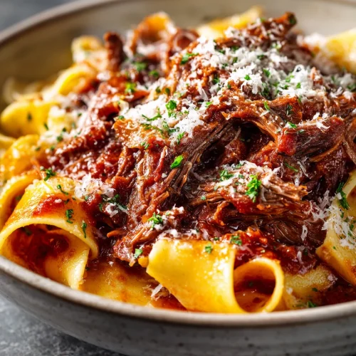 Short rib ragu with pappardelle pasta topped with parmesan cheese