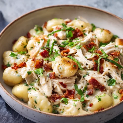 Creamy crack chicken gnocchi topped with bacon and fresh herbs in a bowl