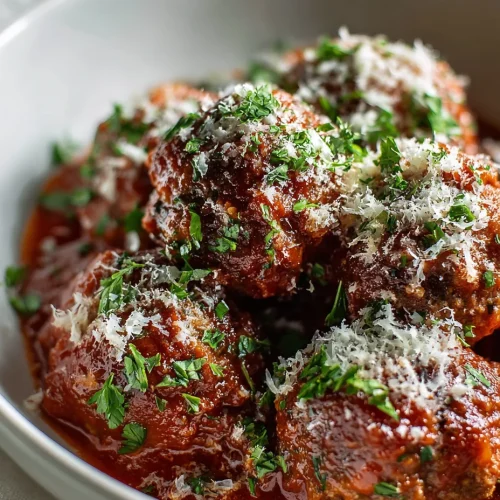 Homemade ricotta meatballs in marinara sauce topped with parmesan and fresh parsley.